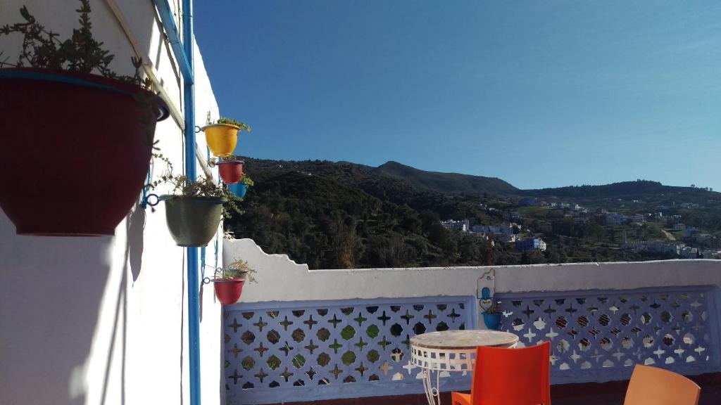 a table and chairs on a balcony with a view at Hostal La Joya in Chefchaouene