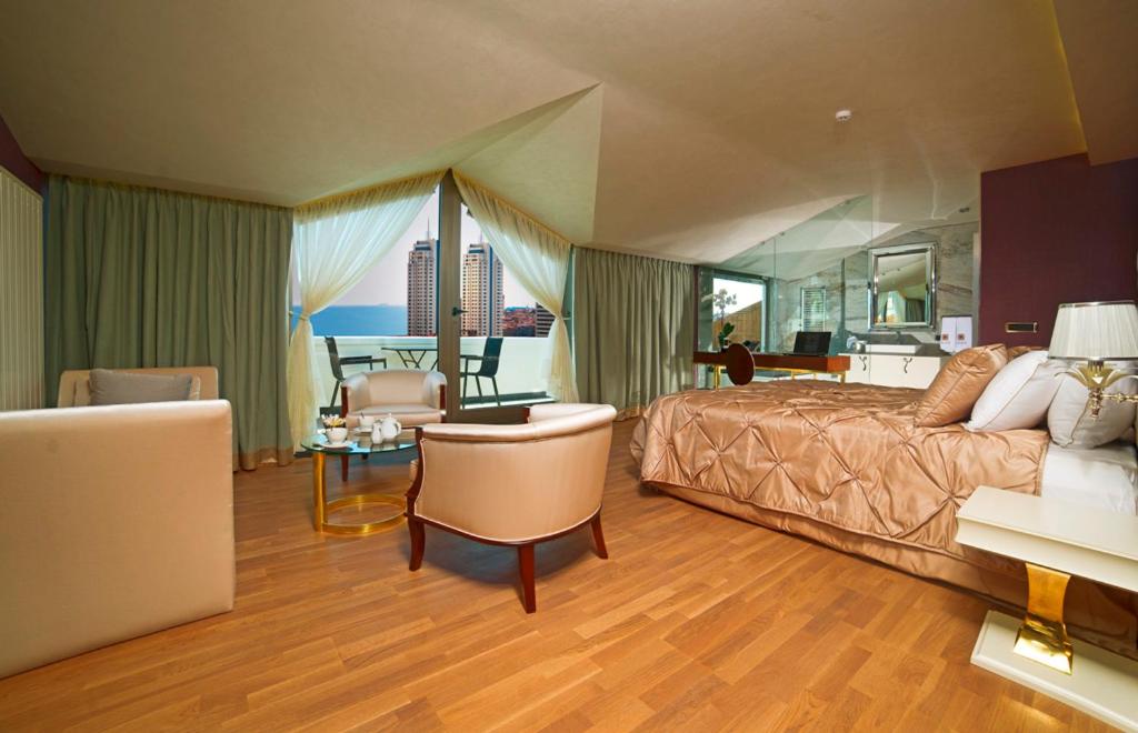 イスタンブールにあるTaba Luxury Suites and Hotelの広いベッドルーム(ベッド1台付)、リビングルームが備わります。