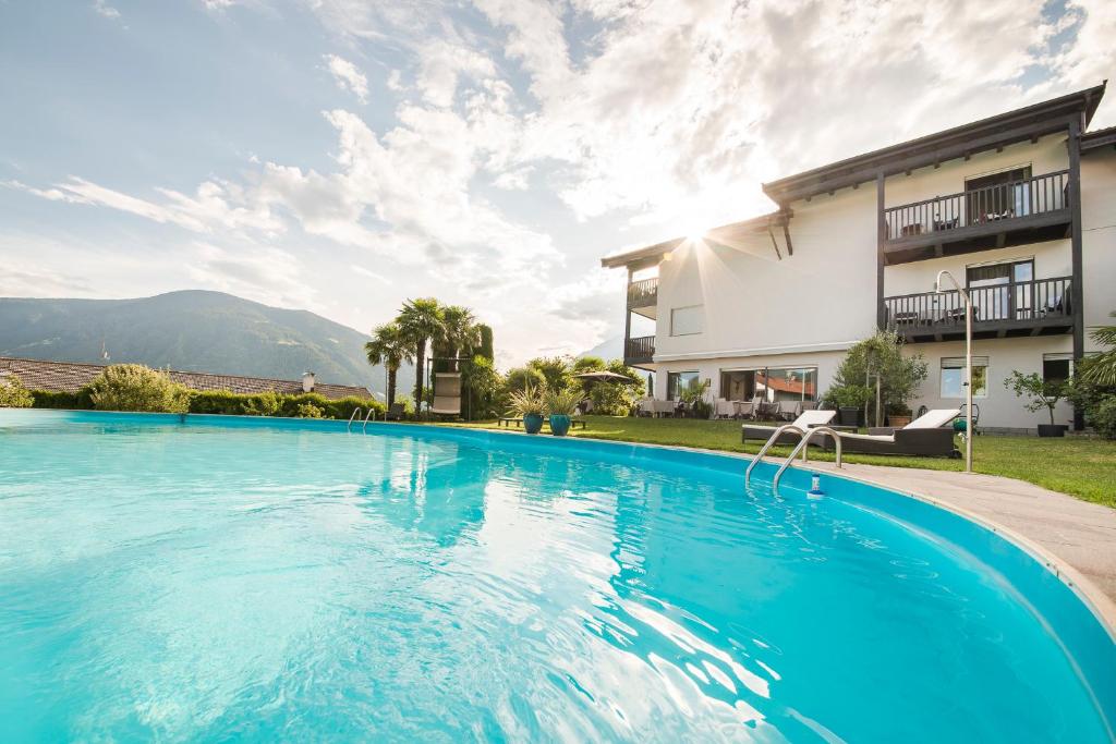 a large swimming pool in front of a house at Boutiquehotel Minigolf in Tirolo