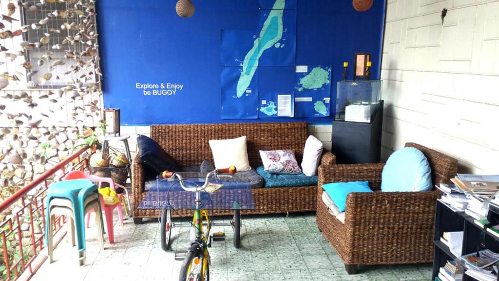 ein Wohnzimmer mit einem Sofa, einem Tisch und einem Fahrrad in der Unterkunft Bugoy Bikers Hostel in Cebu City