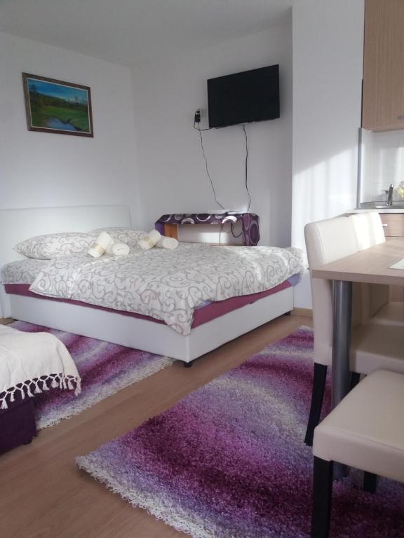 茲拉蒂博爾的住宿－Apartment Bućić，一间卧室配有一张床和紫色地毯