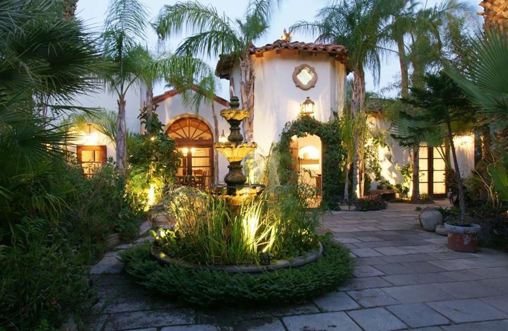 a house with a fountain in the middle of a courtyard at Villa Thornhill in Palm Springs