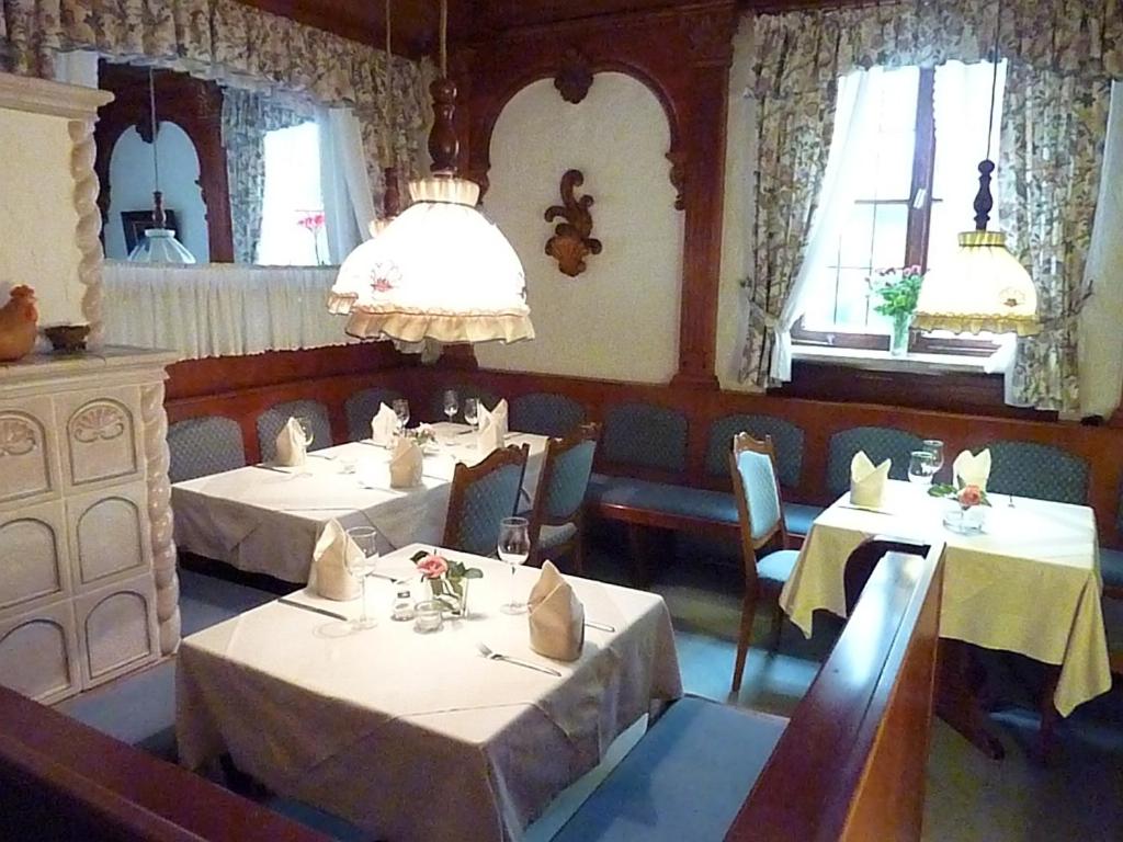 a dining room with two tables and chairs and windows at Braunschweiger Hof in Münchberg