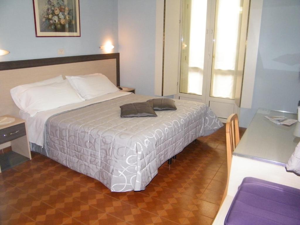 1 dormitorio con cama, mesa y ventana en Hotel Alba Torino centro en Turín