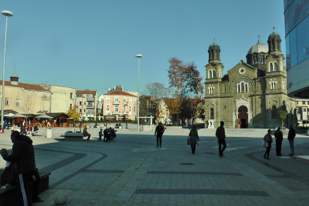 ブルガスにあるTOP CENTER , MODERN AND QUIET APARTMENTの建物前の広場を歩く人々