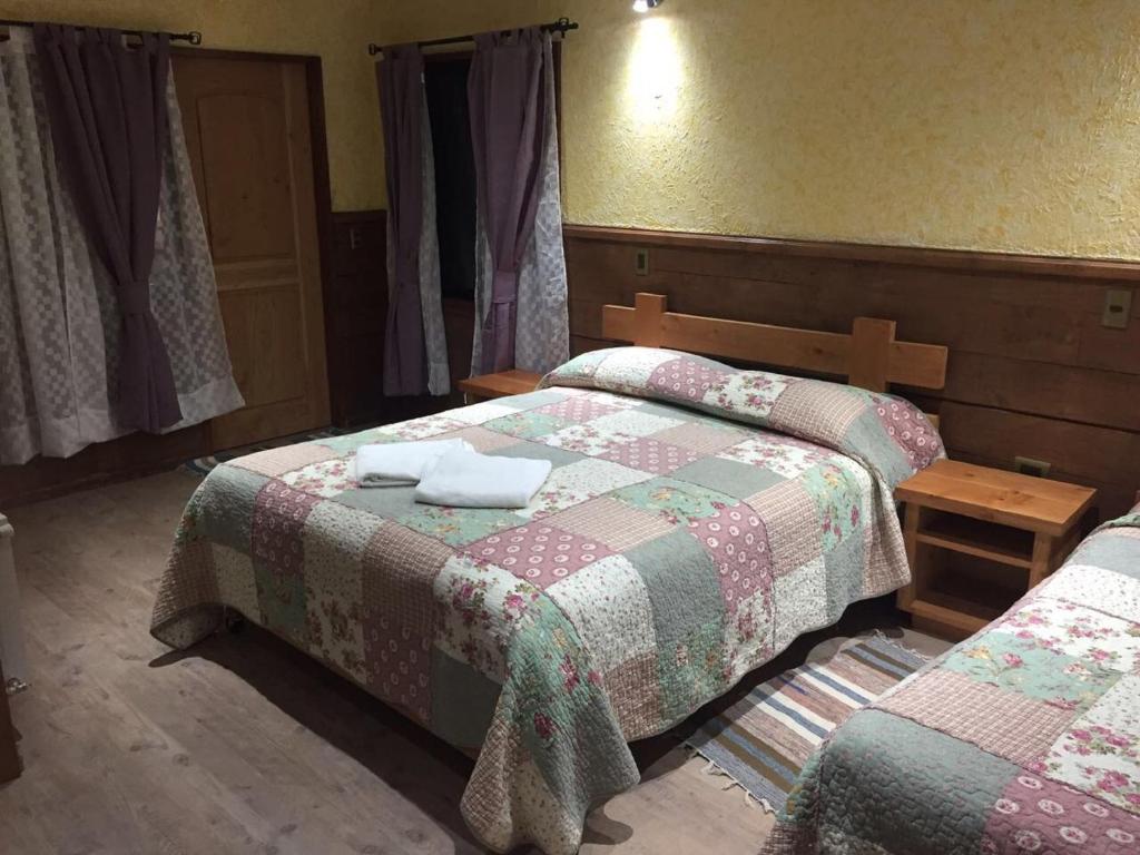 Postel nebo postele na pokoji v ubytování Hostal el Nogal Pucón