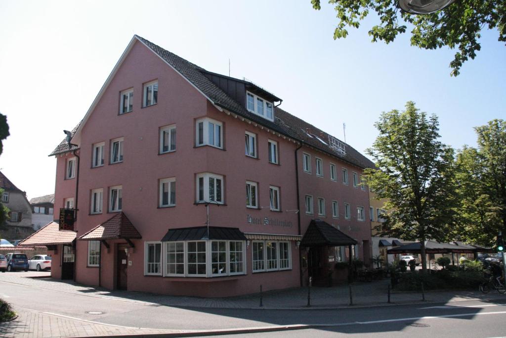 厄赫林根的住宿－席勒鋪拉茨酒店，街道边的一座红色大建筑