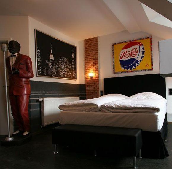 a bedroom with a coca colaacist statue next to a bed at HIP Hotel in Heidelberg