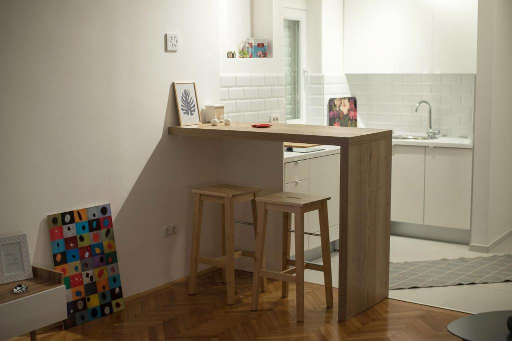 a kitchen with a counter and stools in a room at Bright & Stylish Studio Home, superbly located in Sarajevo