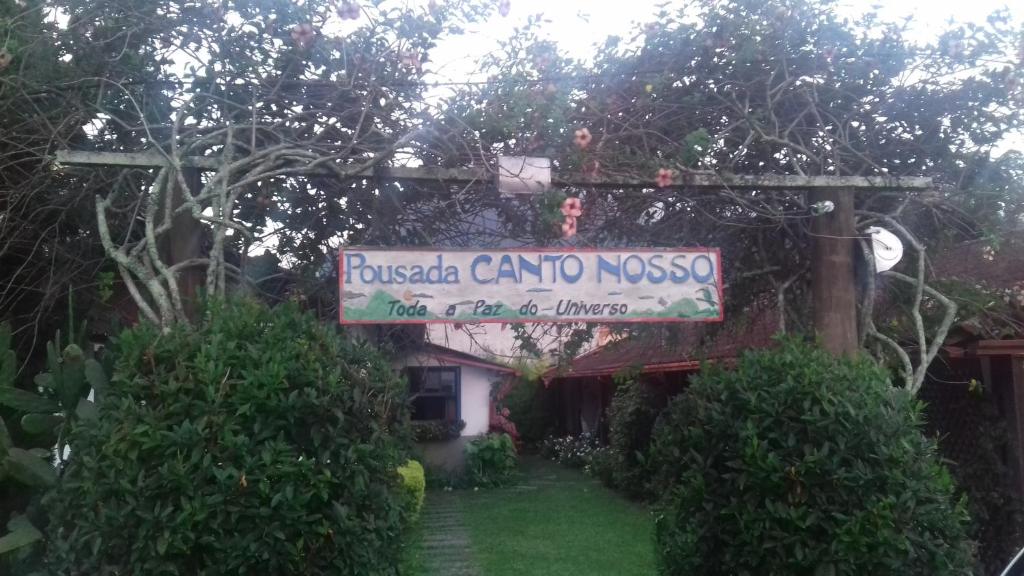 ein Schild vor einem Haus mit Garten in der Unterkunft Pousada Canto Nosso in São Pedro da Serra
