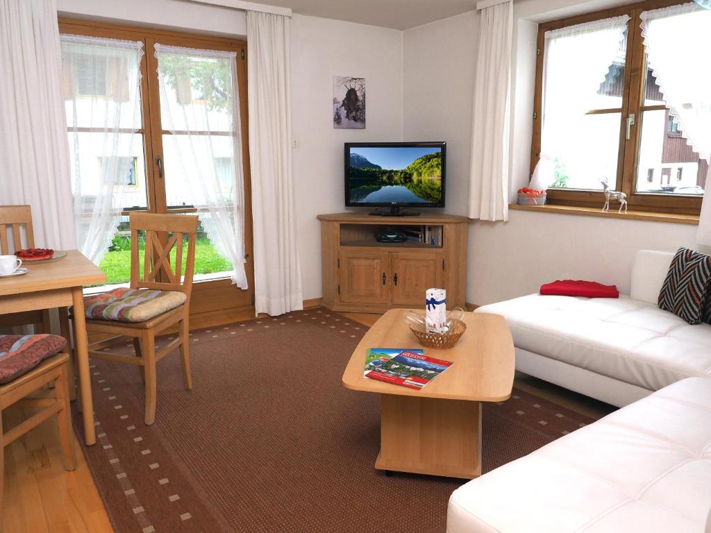 ein Wohnzimmer mit einem weißen Sofa und einem TV in der Unterkunft Haus Antonius in Oberstdorf