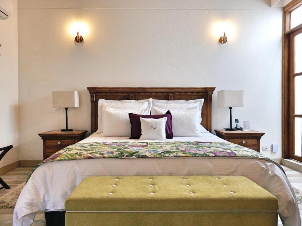 a bedroom with a bed and a dresser at Casa Passiflora Hotel Boutique in Jardin