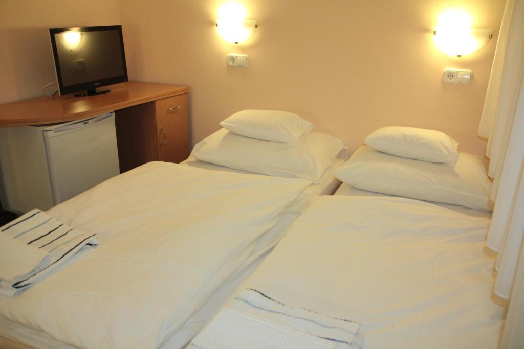A bed or beds in a room at Tisza Corner Hotel