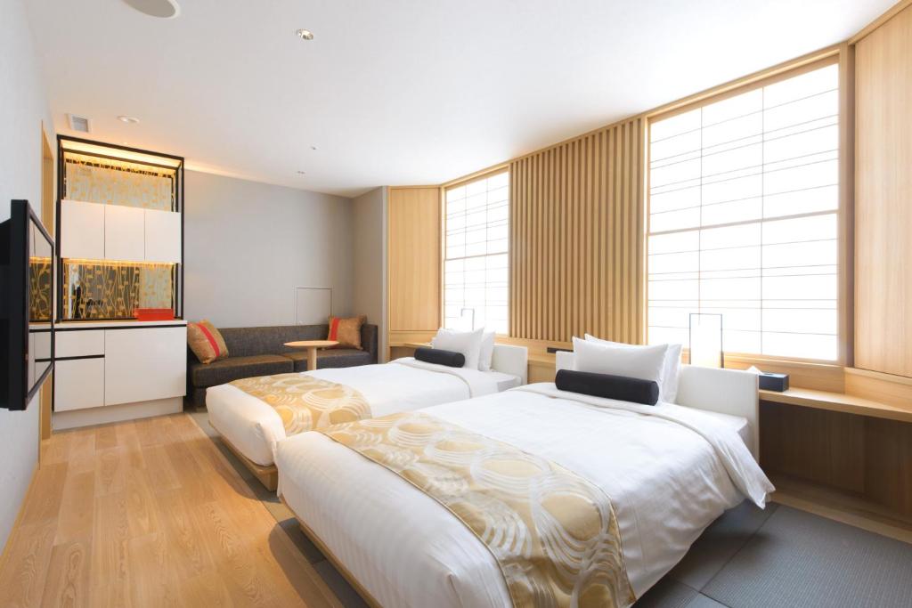 a hotel room with two beds and a television at Kanazawa Tokyu Hotel in Kanazawa