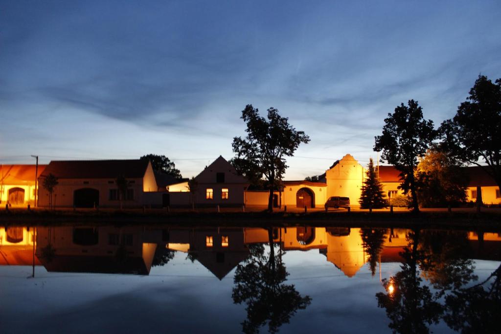 un grupo de casas junto a un lago por la noche en Ubytování U Dvořáků, en Veselí nad Lužnicí