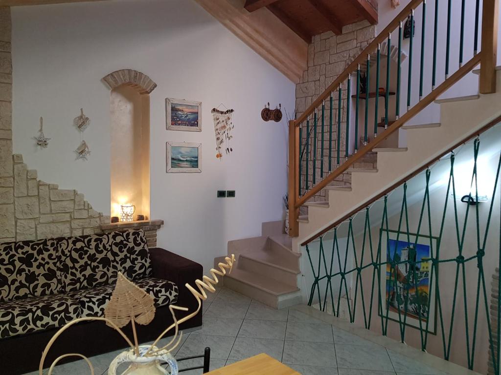 een woonkamer met een bank en een trap bij Residenza Borgo Antico in Termoli