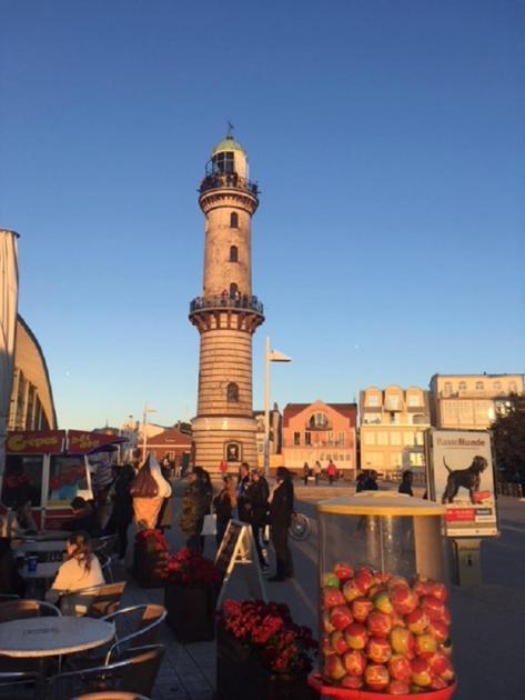 ein Lichthaus mit einem Uhrturm in einer Stadt in der Unterkunft Warnemünder Strandfieber in Rostock