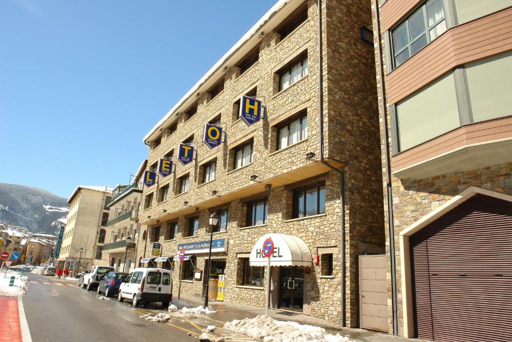 un edificio de ladrillo con un cartel en el costado en Hotel Roc Del Castell en Canillo