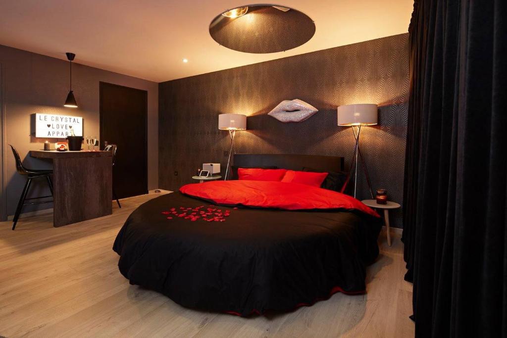 a bedroom with a large bed with red pillows at Crystal Love Appart in Pornichet