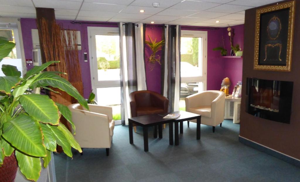 een wachtkamer met stoelen en een tafel in een kamer bij Hôtel Le Cosy Blois Villebarou in Blois