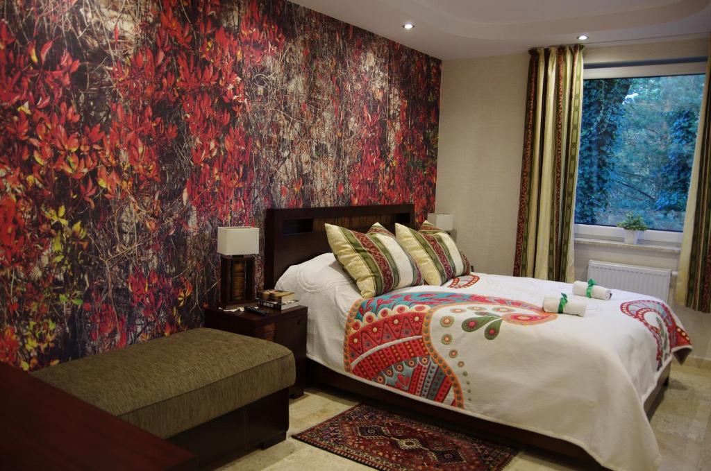 ユラタにあるJurata Dzikie Winoの赤い壁のベッドルーム1室(ベッド1台付)