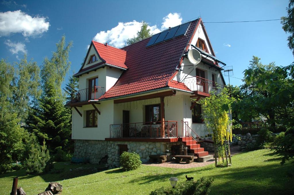willa Relaks في كوشتيليسكا: منزل بسقف احمر على ساحة خضراء