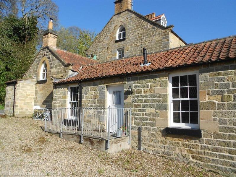 an old brick building with a gate in front of it at Everley Cottage in Scarborough