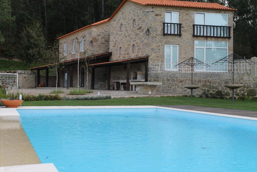 a house and a swimming pool in front of a house at Quinta Anna Horvath in Vale de Cambra