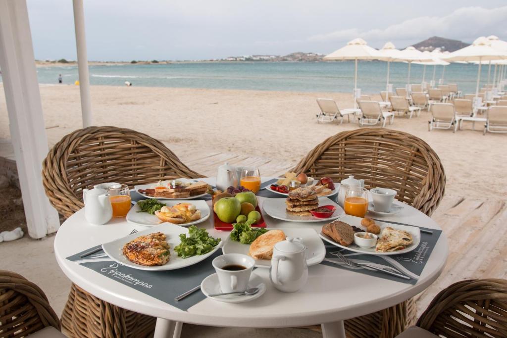 uma mesa com pratos de comida na praia em Ippokampos Beachfront em Naxos Chora