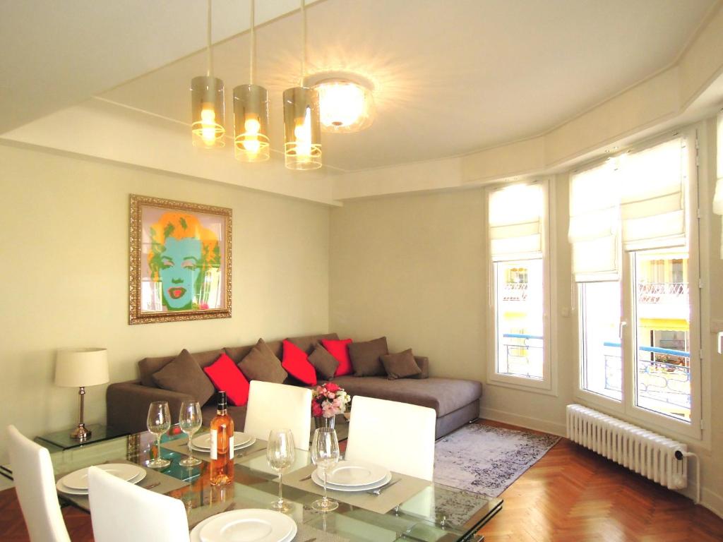 un salon avec une table et un canapé dans l'établissement Le Massenet France, à Nice