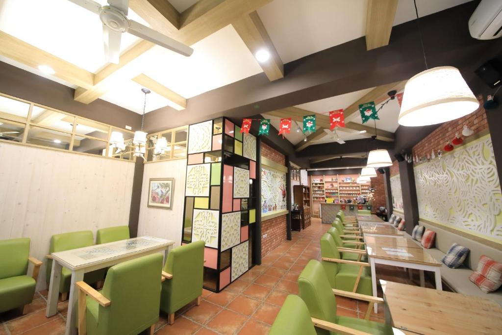 una sala da pranzo con tavoli e sedie verdi di Feather and Flowers Homestay a Ji'an