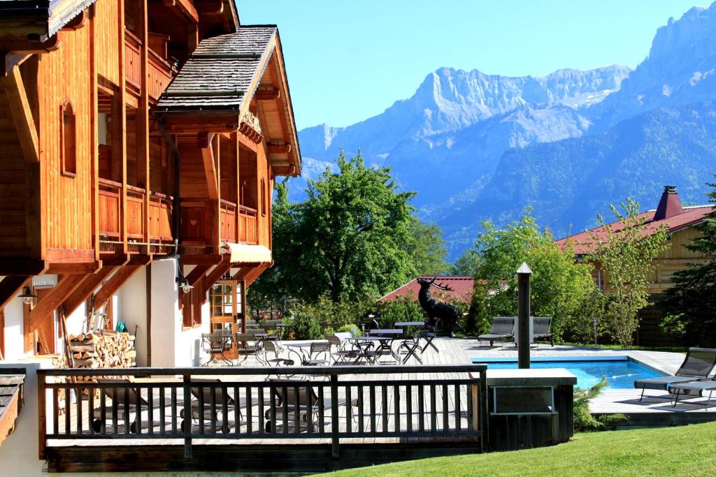uma casa com uma varanda com piscina e montanhas em Le Cerf Amoureux Chalet Privé & Spa em Sallanches