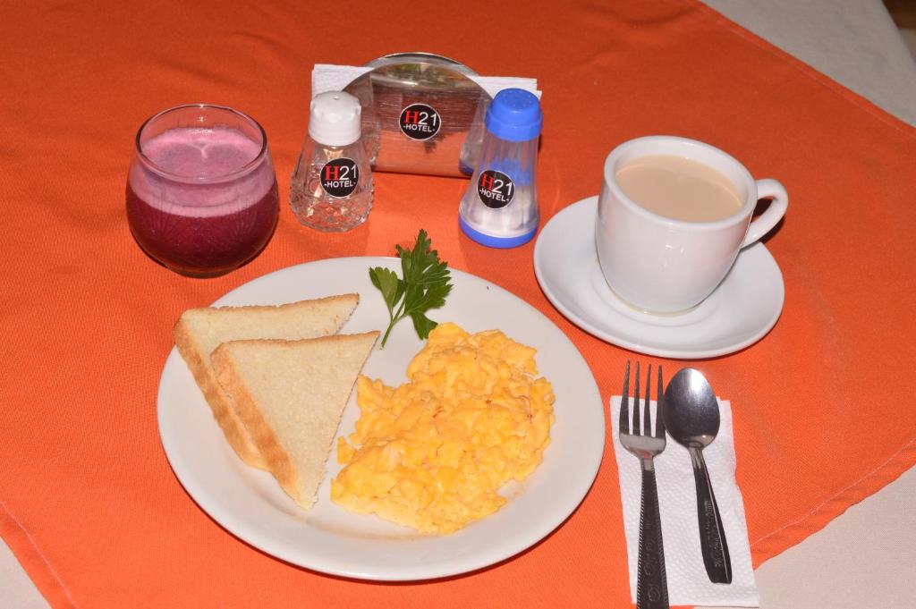 einen Tisch mit einem Teller Eiern, Toast und einer Tasse Kaffee in der Unterkunft Hotel H21 in Cali