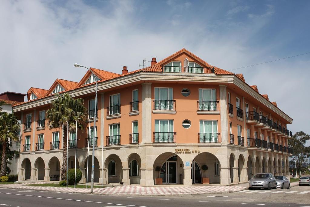 a large orange building on the side of a street at Hotel Bahía Bayona in Baiona