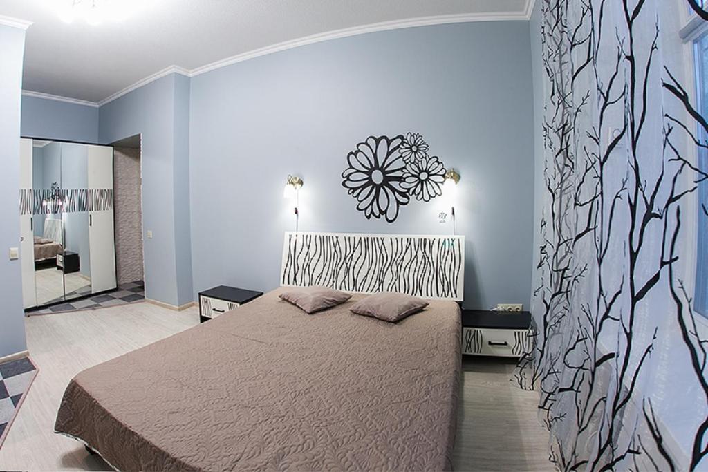 een slaapkamer met een bed en een muur met een bloem erop bij Квартира в центрі на вулиці Краківька 34 біля Площі Ринок in Lviv