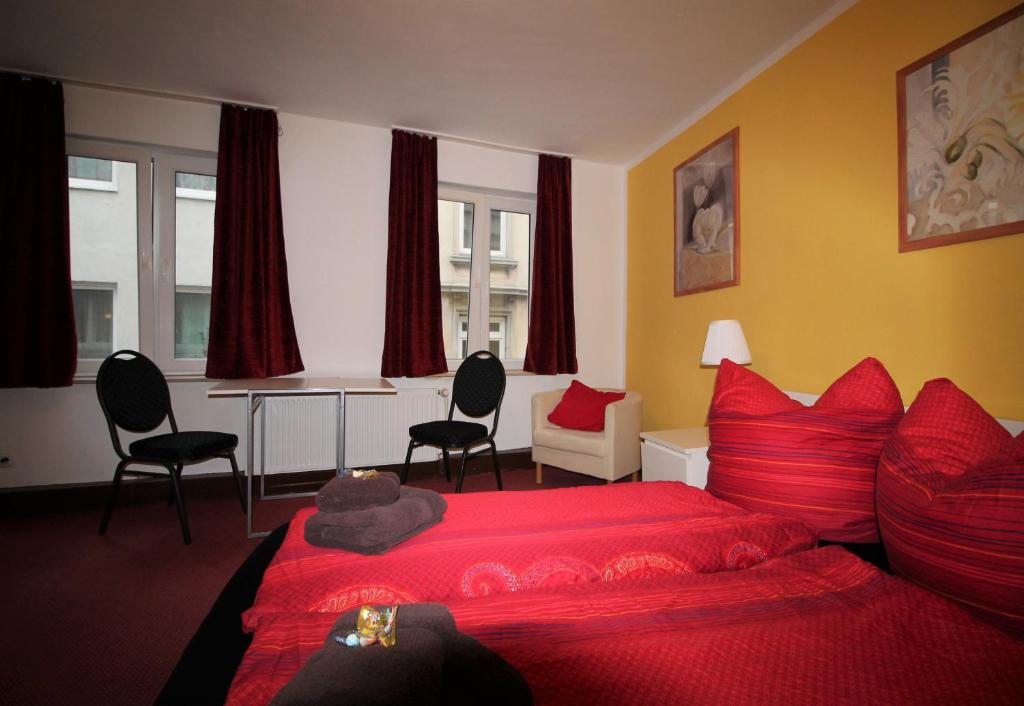 a bedroom with a red bed and a table and chairs at Sleep in Hamburg St. Pauli in Hamburg