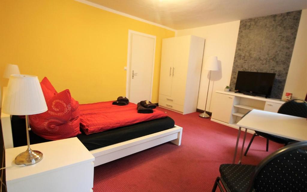 漢堡的住宿－Sleep in Hamburg St. Pauli，一间卧室配有一张带红色枕头的床和电视。