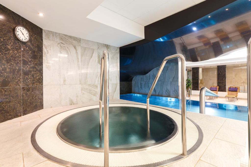 a hot tub in a bathroom with a swimming pool at Hotel Thermal in Karlovy Vary
