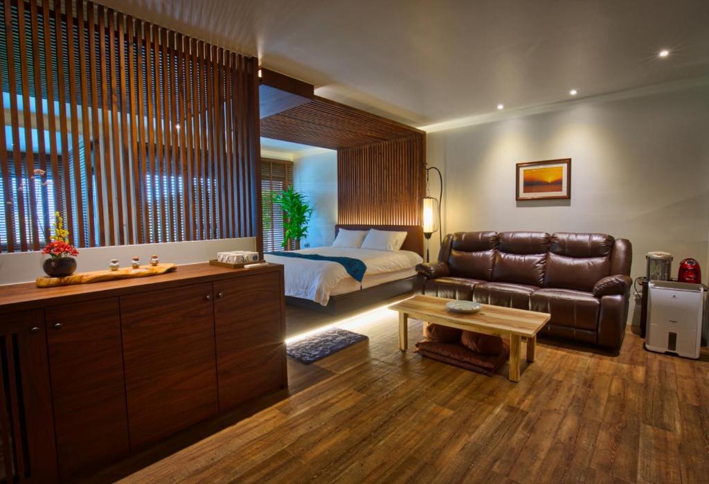 um quarto com uma cama, um sofá e uma mesa em The Sunbeam Hideaway B&B em Luodong