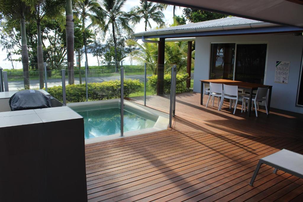 a deck with a swimming pool next to a house at Banfields Retreat in Mission Beach