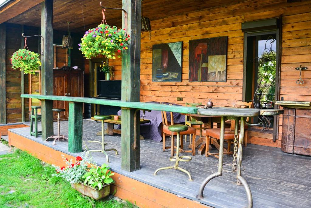 une terrasse couverte d'une maison avec une table et des chaises dans l'établissement Gallery Guest Rooms, à Kernavė