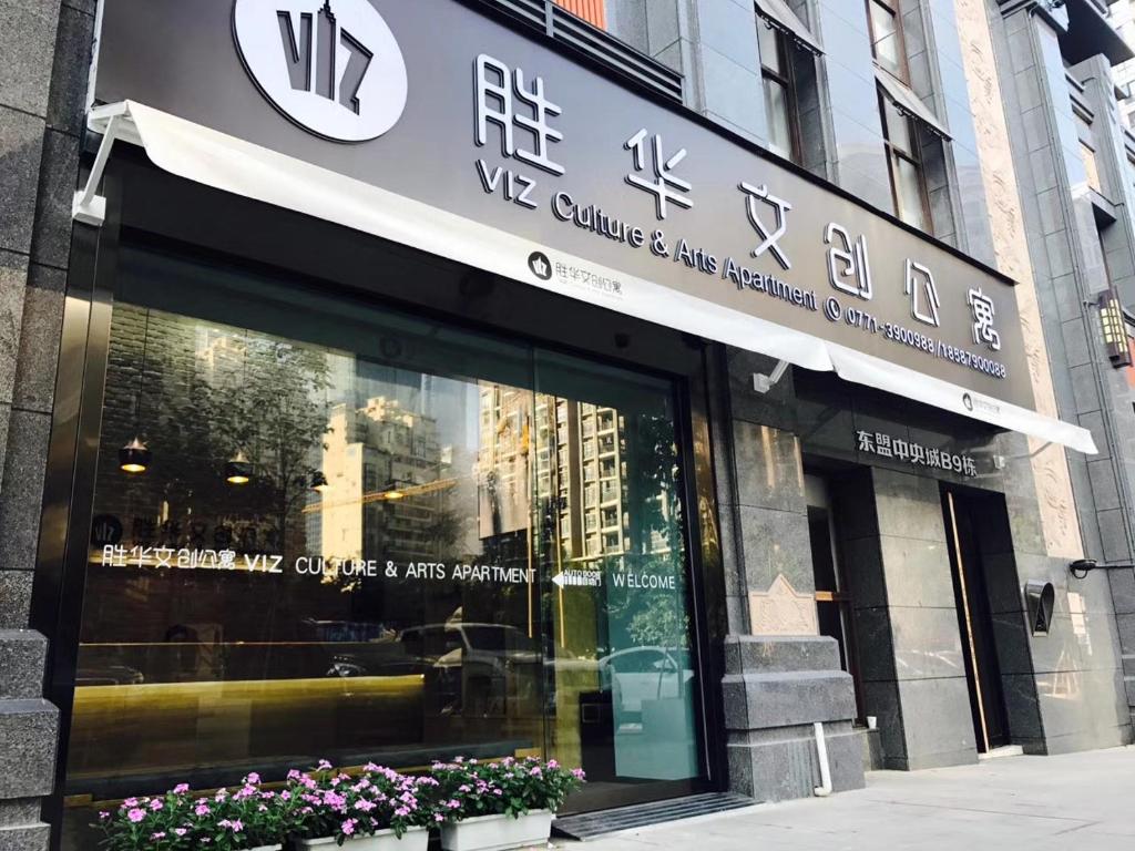 een winkel voor een gebouw met een bord erop bij VIZ Culture & Arts Apartment in Nanning