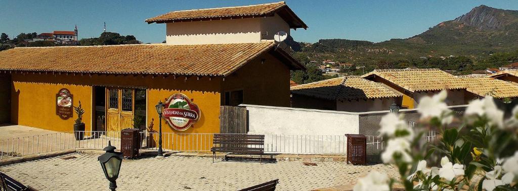 a bird standing in front of a yellow building at Pousada Vivendas Da Serra in Catas Altas