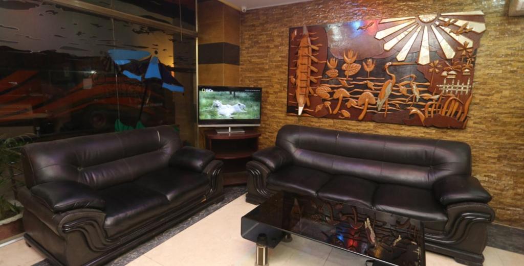 un soggiorno con 2 sedie in pelle e una TV di Grand Beach Resort a Cox's Bazar