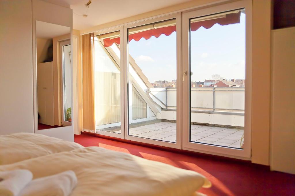 a bedroom with a large window and a balcony at Ferienwohnung Geestemuende in Bremerhaven