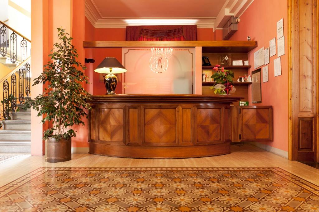 una sala con un banco de madera en un edificio en Hotel Savoia e Campana, en Montecatini Terme