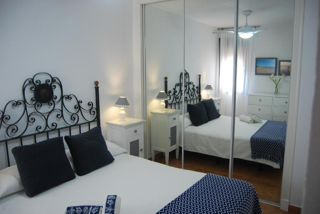 a bedroom with two beds and a mirror at Atlanterra Sol in Zahara de los Atunes