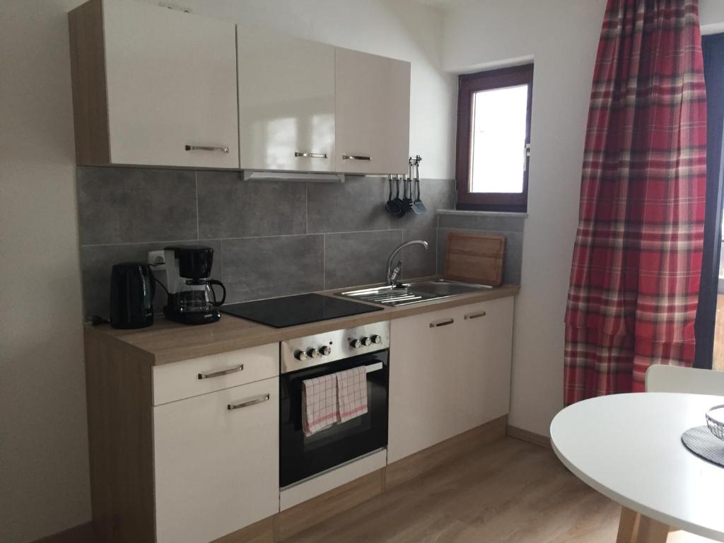 a small kitchen with a sink and a stove at Gästehaus Wagner in Grainau