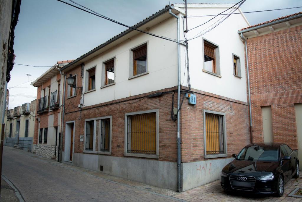 a car parked in front of a brick building at Apartamentos Alameda in Coca