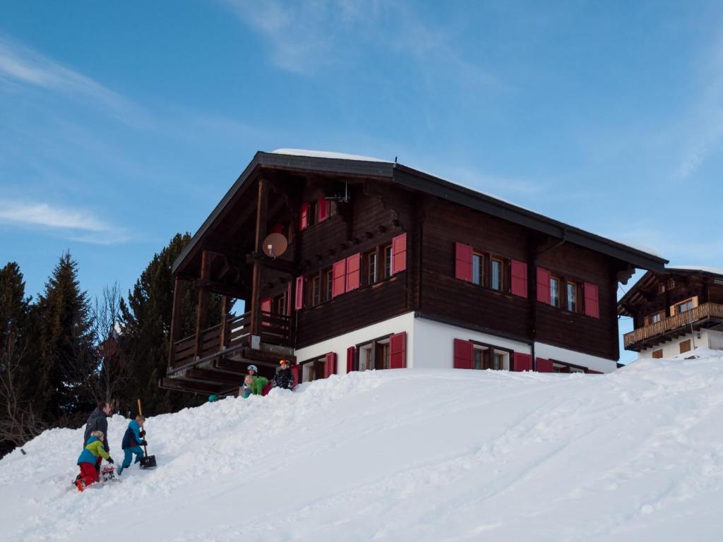 a group of people standing in the snow in front of a building at Chalet Gerbera in Rosswald